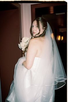 a woman in a wedding dress holding a bouquet