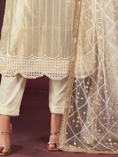 Presenting an exquisite off-white net kameez adorned with intricate threadwork, sequin detailing, and a fancy readymade lace border for an elegant touch. Paired seamlessly with a crepe salwar in a matching off-white shade, this ensemble exudes timeless sophistication and style.
Completing the look is a net dupatta in a similar off-white color, featuring sequin work, thread embroidery, and a fancy lace border. The 2.5-meter-long dupatta adds a graceful layer to the outfit, enhancing its overall a Elegant Cream Sharara For Navratri, Unstitched Off White Sharara With Sheer Dupatta, Off White Salwar Kameez With Sheer Dupatta For Diwali, Elegant Off White Salwar Kameez For Navratri, Cream Sharara With Sheer Dupatta For Diwali, Designer Wear Festive Off White Salwar Kameez, Traditional Cream Churidar With Sheer Dupatta, Designer Wear Off White Salwar Kameez For Festivals, Elegant Churidar With Sheer Dupatta For Navratri