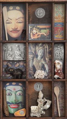 an assortment of decorative items displayed in a wooden box with multiple pictures on the wall