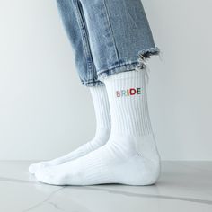 a person wearing white socks with the word bride written on them, and ripped jeans