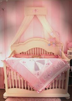 a baby crib with pink and white striped walls