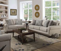 a living room with two couches and a coffee table in front of large windows