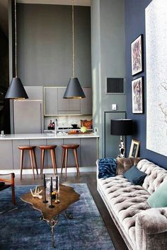 a living room filled with furniture next to a kitchen