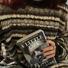 a woman with red hair is holding a book