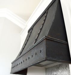 a black stove top oven sitting inside of a white kitchen wall with the hood up