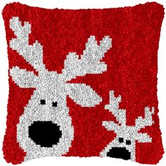 a red and white pillow with reindeer on it