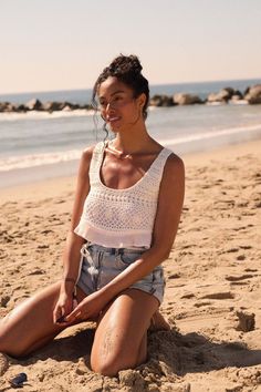 Solid crepe and crochet lace tank top. Scoop neckline. Crochet lace bodice. Sleeveless. Low scoop back with tasseled lace-up closure. Ruffle hem. Cropped length. Relaxed fit. 100% Rayon. Imported. Designed in LA. Model wears size S. Summer Cropped Lace Tank Top, Summer Tank Top With Lace Trim And Scoop Neck, White Crochet Lace Sleeveless Crop Top, Summer Lace Trim Crop Top Tank, Sleeveless Crochet Lace Crop Top, Beach Crochet Camisole Top With Lace Trim, Summer Tank Top With Lace Trim For Beach, Summer Beach Tank Top With Lace Trim, Lace Crochet Camisole Top For Beach