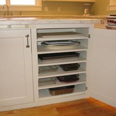 an open cabinet in the middle of a kitchen