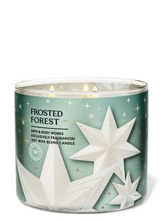 frosted forest candle tin with white paper stars on the front and green back ground