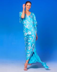 Ava Silk Kaftan in Turquoise and Silver Motif walking front view Blue V-neck Kaftan For Evening, Elegant Blue Floral Print Kimono, Blue Silk Kaftan With Kimono Sleeves, Elegant Blue Silk Kaftan, Spring Blue Silk Kaftan, Blue Silk Kaftan For Spring, Blue Kaftan For Spring Evening, Blue Kaftan For Evening In Spring, Blue Evening Kaftan For Spring