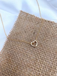 "A Timeless Symbol of Love and Elegance ❤ Elevate your style with the Delicate Gold Heart Necklace, a stunning jewelry piece that combines grace and sophistication.  Crafted with meticulous attention to detail, this necklace boasts a dainty hollow heart shaped pendant made of non tarnish Gold plated. It's minimalist design allows for versatility, effortlessly complementing any attire, whether it's a casual day out or a formal occasion. As a symbol of love and beauty, the Gold Heart Necklace hold Dainty Heart-shaped Hallmarked Necklace, Hallmarked Heart-shaped Dainty Necklace, Minimalist 14k Gold-filled Heart Necklace, Dainty Heart-shaped Brass Necklaces, 14k Yellow Gold-filled Heart Necklace For Valentine's Day, Heart Shaped Pendant, Hollow Heart, Timeless Symbol, Gold Heart Necklace