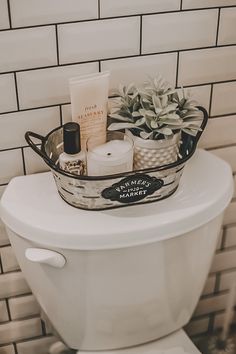 a white toilet sitting in a bathroom next to a tiled wall