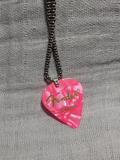 a pink heart shaped keychain that says fenderer on it's side