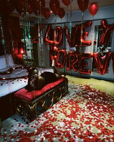 a room with balloons and confetti all over the floor that says love is forever