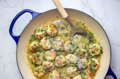 a pan filled with meatballs covered in gravy and parmesan cheese