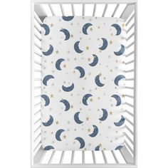 a white crib with stars and crescents on the sheet in front of it