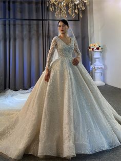 a woman in a wedding dress standing next to a chandelier