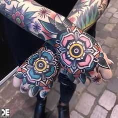 two people with tattoos on their arms holding each other's hands in front of them