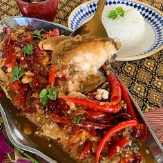 a plate full of food on a table with rice and other dishes in the background