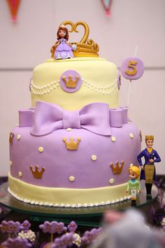 a birthday cake with princess and prince figurines on top