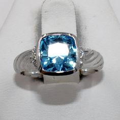 "Beautiful 62.5 carat Swiss blue topaz in a unique vintage 14K white gold ring with diamond accents.  Marked \"14K\".  A wonderful addition to your personal jewelry collection. FREE SHIPPING! Details:  14K Yellow Gold: (as shown in picture) Topaz:  (1) 8 mm x 8 mm cushion cut Approximate Gem Weight: 6.5 carats Gem Color:  Swiss Blue Ring Size: 7 Total Weight: 5.4 grams FREE domestic shipping by USPS Priority Mail Delivery Confirmation and includes insurance. If the item is to be shipped internationally Etsy will calculate postage. Please notify us at purchase if you are buying more than one item and we will gladly combine shipping. 7 day \"no hassle\" return policy money back guarantee. If for any reason you are not 100% thrilled with your purchase, please contact us and we will gladly acc Blue Square Cut Blue Topaz Jewelry, Blue Square-cut Gemstone Rings, Gold Ring With Diamond, Swiss Blue Topaz Necklace, Gold Vintage Ring, Square-cut Blue Topaz Gemstone Jewelry, Swiss Blue Topaz Ring, Personal Jewelry, Blue Ring