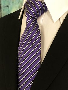 "Mens 100% silk purple stripe necktie. Features a purple backgroung with narrow black and white stripe. Available as a long Tie. Handmade from 100% silk, this special collection features a .75\" Eds Neckties logo at the bottom right front corner of every tie and a larger logo located on the tipping (Back of the tie). The label features the collection name (Nathaniel Alexandria) Named after my son Nathaniel and my daughter Alexandria. Expertly hand-made from 100% silk you can select your length f Striped Business Neckwear Ties, Striped Business Neckwear, Classic Lavender Tie For Business, Classic Purple Neckwear For Formal Occasions, Formal Purple Neckwear With Ties, Formal Purple Standard Tie, Purple Standard Tie For Black Tie Events, Purple Suit And Tie Accessories For Black Tie Events, Fitted Purple Suit And Tie Accessories For Office