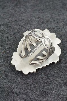 This White Buffalo and sterling silver ring was made by Navajo silversmith Tom Lewis. The back is signed and stamped sterling.Size: 9.25Length: 1 5/8"Width: 1 1/4"Free shipping on all orders! We ship with USPS and always include tracking. All orders ship within a day of payment.Returns are accepted up to 30 days after you receive your order. Just send us a message. Our shop offers cash back or store credit. The item must be returned in new condition. Silver Turquoise Concho Ring In Sterling Silver, Sterling Silver Stamped Turquoise Ring, Stamped Sterling Silver Turquoise Ring, Silver Engraved Southwestern Turquoise Ring, Engraved Silver Turquoise Ring In Southwestern Style, Engraved Silver Southwestern Turquoise Ring, Engraved Silver Turquoise Southwestern Ring, Tom Lewis, White Buffalo