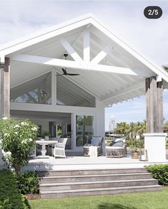 an outdoor living area with white furniture and wooden steps