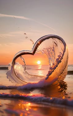 a heart shaped object floating on top of the ocean at sunset with waves crashing around it