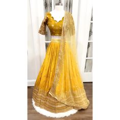 Title: "Elegant Shimmery Sequin Lehenga Choli - Size 42 - Heavy Partywear Dress for Haldi - Scallop Design Blouse - Stitched" Description: Elevate your haldi ceremony with our exquisite Shimmery Sequin Lehenga Choli. Crafted with meticulous attention to detail, this stunning ensemble is perfect for making a statement on your special day. The lehenga features intricate sequence work that shimmers and shines with every move, while the scallop design blouse adds a touch of elegance. Stitched to per Fitted Floor-length Sharara With Zari Work, Fitted Gold Organza Traditional Wear, Gold Fitted Organza Traditional Wear, Fitted Art Silk Salwar Kameez Chandbali, Fitted Dola Silk Sharara With Dori Work, Fitted Anarkali Choli In Organza, Fitted Anarkali Organza Choli, Fitted Gold Lehenga With Chandbali Shape, Fitted Sharara With Dori Work For Navratri