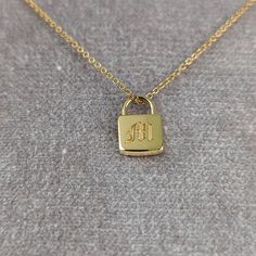 "Personalized lock pendant that is engravable on the front and back with the font of your choice. The necklace can be bought as a standalone pendant or a full necklace with a high quality Italian imported cable chain. DETAILS - Made in U.S.A - Choose between 14, 18k or Platinum.  - Buy as standalone pendant or with chain as a necklace. - Optional chain is a Italian imported 1.2mm 16-18\" adjustable cable chain with lobster clasp. - Ships worldwide via FedEx/DHL with end to end insurance. Can't find what you're looking for? We also create custom designs from idea through to fabrication. Contact us today to get started, we'd love to hear from you: http://etsy.me/1231fkN BEHIND THE SCENCES Pinterest: www.pinterest.com/sevgijewelry Instagram: www.instagram.com/sevgi_jewelry Thanks for visiting Personalized Yellow Gold Square Pendant Jewelry, Gold Charm Necklace With Engraving For Anniversary, Luxury Engraved Charm Necklace For Gift, Engraved 14k Gold Charm Necklace For Anniversary, Yellow Gold Rectangular Charm Necklaces For Anniversary, Yellow Gold Rectangular Charm Necklace For Anniversary, Rectangular Yellow Gold Charm Necklace For Anniversary, Everyday Yellow Gold Jewelry With Hallmarks, Mother's Day Jewelry