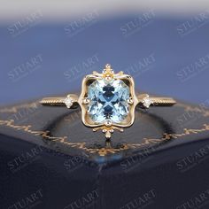 an engagement ring with a blue topazte surrounded by white and yellow gold accents