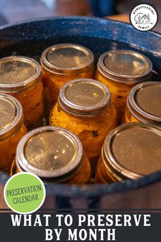 several jars filled with pickles sitting on top of a table next to the words what to preserve by month