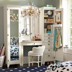 a bedroom with a desk, mirror and dressing room furniture in it's corner