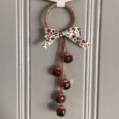 a door hanger with bells hanging from it's side and a bow on top