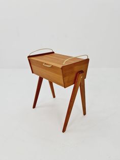 a small wooden table with legs and a tray on it's top that is bent to the side