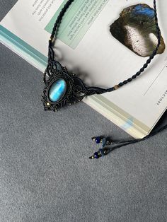 an open book with a necklace and some beads on it