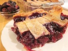 a piece of pie sitting on top of a white plate next to a bowl of fruit