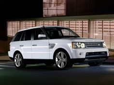 a white range rover parked in front of a building