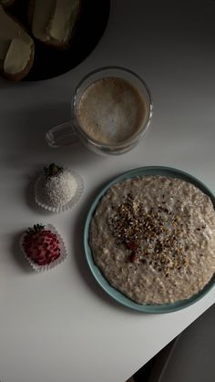 a bowl of oatmeal with strawberries next to it