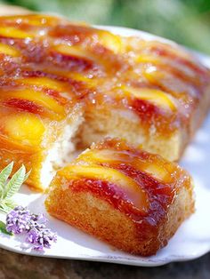 a piece of pineapple upside down cake on a plate next to some lavender flowers