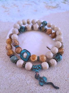 Get those sandy vibes flowing with our Beachy Bracelets, featuring natural stones, patina green accents, pearls, and cute ocean-inspired charms. Our Mykonos Collection would not be complete without some versatile, easy-to-use stretch bracelets. Wear one alone or stack a few for a bold BoHo look. Each bracelet features antiqued patina charms and spacers made in Greece, where the art of metal finishing was popular already thousands of years ago. Pearls, stingrays, shells, and other fun shapes ador Beachy Bracelets, Bold Boho, Patina Green, Ocean Bracelet, Ocean Inspired Jewelry, Beach Bracelets, Beads Bracelet Design, Ocean Inspired, Natural Stone Bracelets