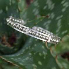 So beautiful! These are 4mm smooth sterling silver beads circling your wrist in a simple sterling silver wire-wrapped bracelet. A bit fancier than the classic wirewrap, but still stackable with many of my other bracelets! The built-in hook and eye-type clasp is easy to get on and off. Wear it every day--it's guaranteed to get noticed! Choose your size from the variations listed for a perfect fit! Also available in all 14kt gold filled, and in two-tone. Sterling Silver Bangle Bracelet With Silver Beads, Adjustable Silver Hand Wrapped Bracelets, Adjustable Hand Wrapped Silver Bracelets, Adjustable Sterling Silver Beaded Bangle Bracelet, Sterling Silver Bangle With Silver Beads, Silver Minimalist Hand Wrapped Bracelets, Elegant Hand Wrapped Silver Cuff Bracelet, Sterling Silver Hand Wrapped Cuff Bracelet Gift, Elegant Handmade Silver Wrap Bracelet