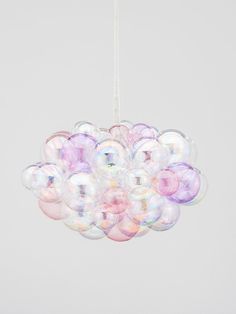 a chandelier made out of bubble balls hanging from a white ceiling light fixture