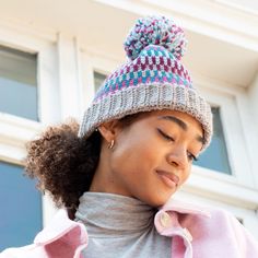 a woman wearing a knitted hat looking at her cell phone