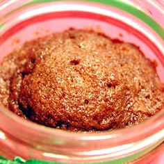 a close up of a food in a glass jar on a green and pink table cloth