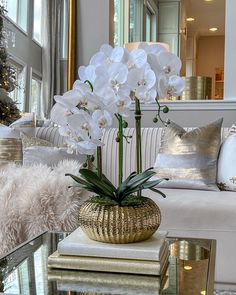 a living room filled with lots of furniture and flowers in a vase on top of a table