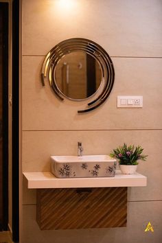 a bathroom sink sitting under a round mirror next to a wall mounted faucet