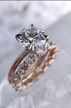 a close up of a diamond ring on a marble surface