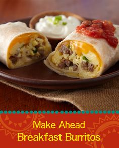 a burrito on a plate with salsa and sour cream in the background text reads make ahead breakfast burritos